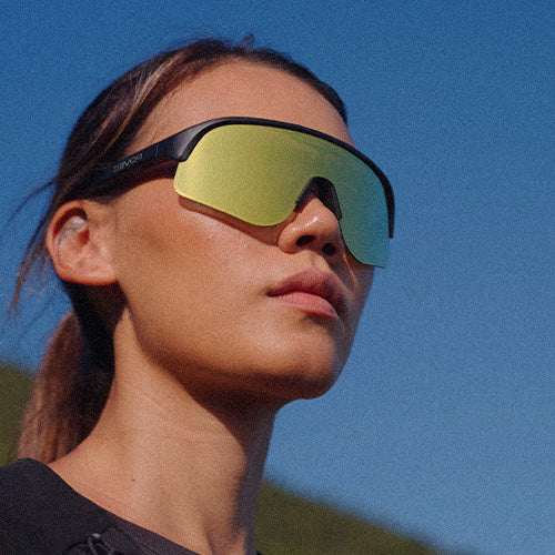 Person wearing reflective sunglasses against a clear blue sky