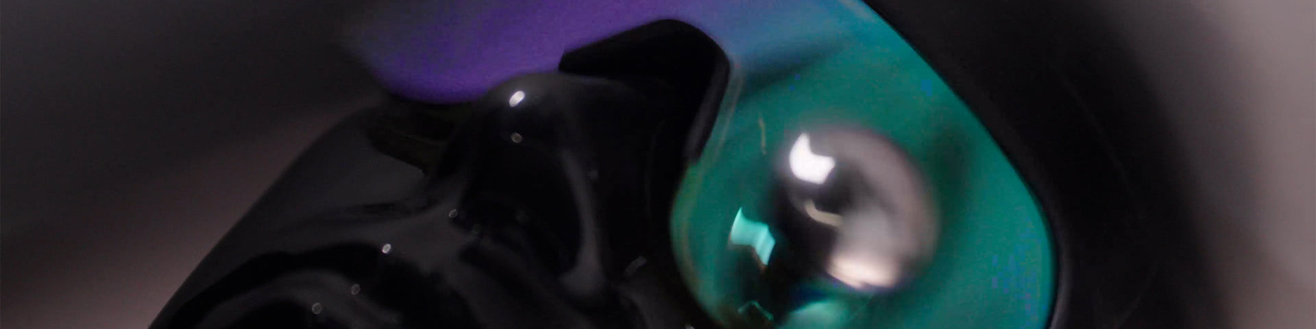 Close-up of a black and teal electronic device with a reflective surface.