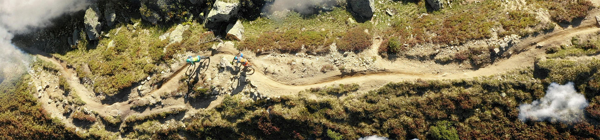 Model of a mountain bike trail with riders on a grassy landscape