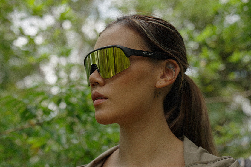 Woman wearing reflective sunglasses with a blurred natural background